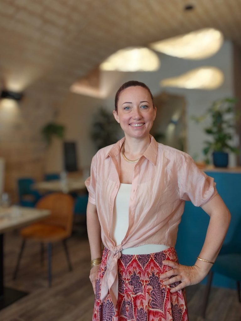 Jennifer Henriksen souriante prête à servir la clientèle.